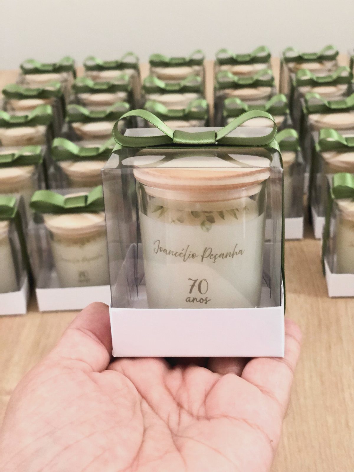 Personalized white candle in a gift box with a green ribbon and wooden lid