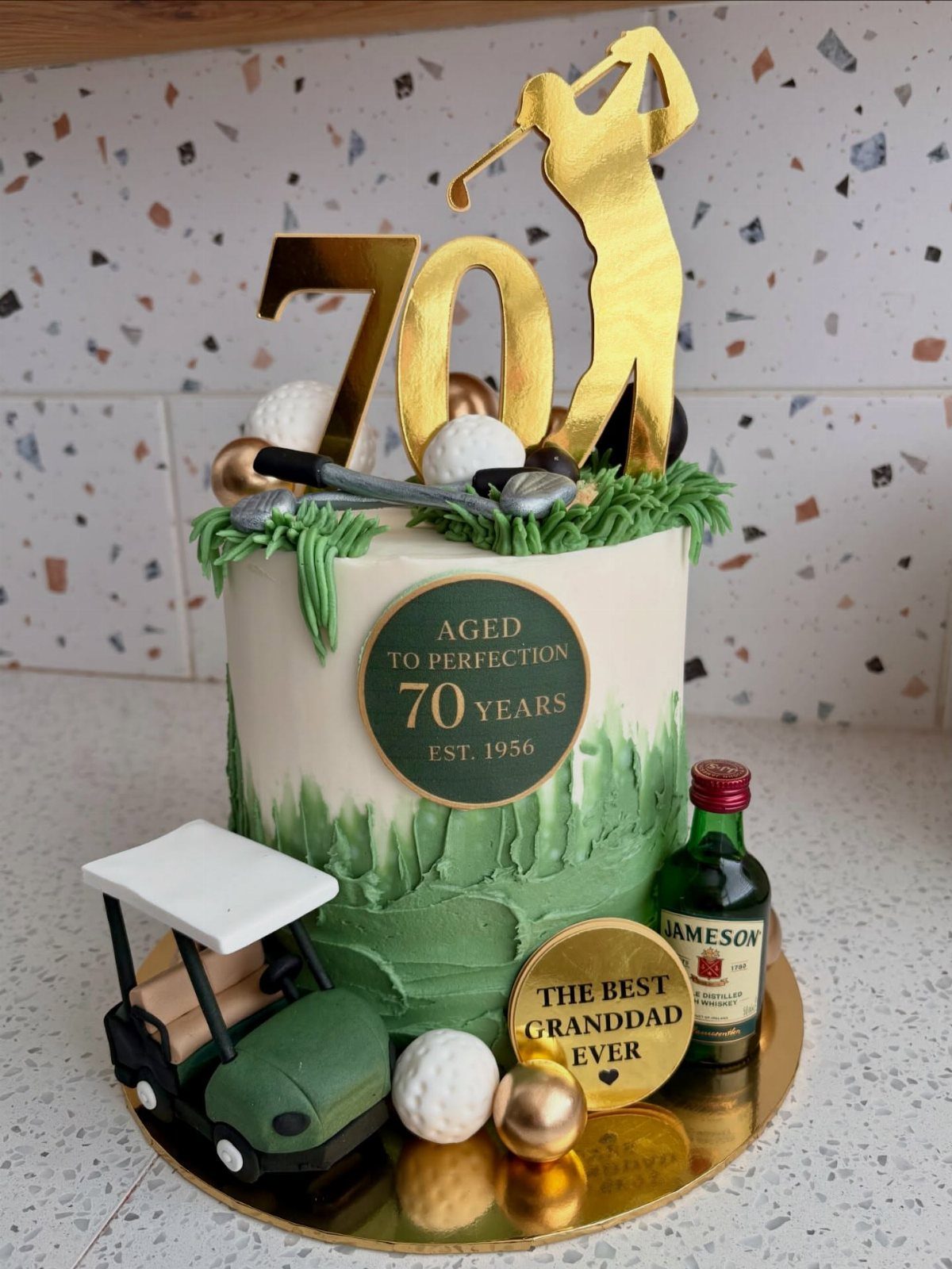 Golf themed 70th birthday cake with a miniature golf cart and whiskey bottle.