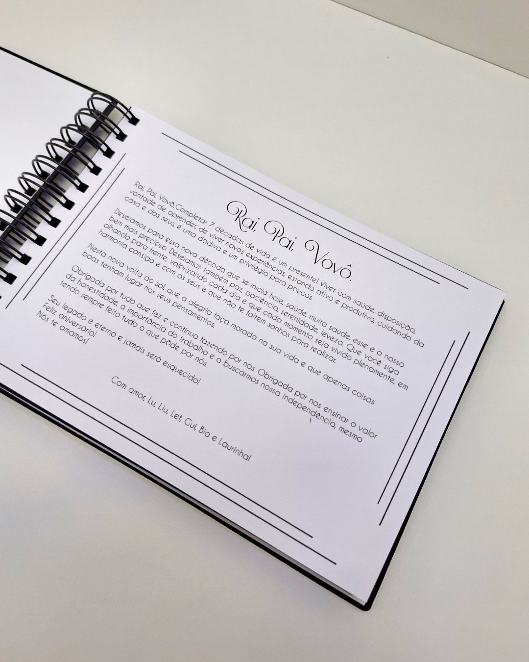 Open spiral-bound memory book with a printed letter on a white background