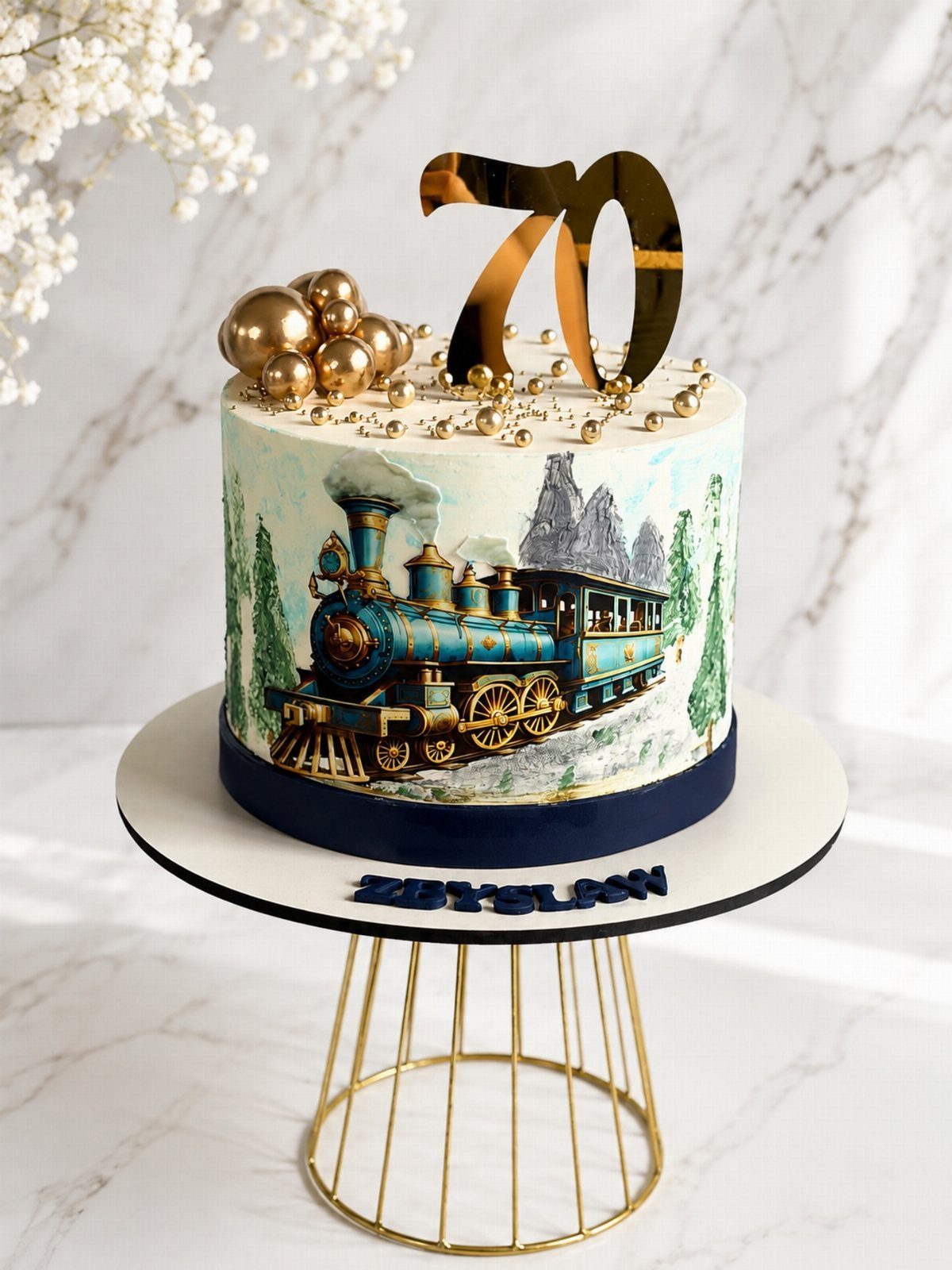 White birthday cake with a blue steam train image and gold 70 topper.