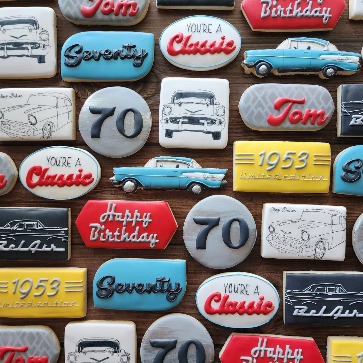 Decorated birthday cookies featuring vintage cars and the number 70 on wood.