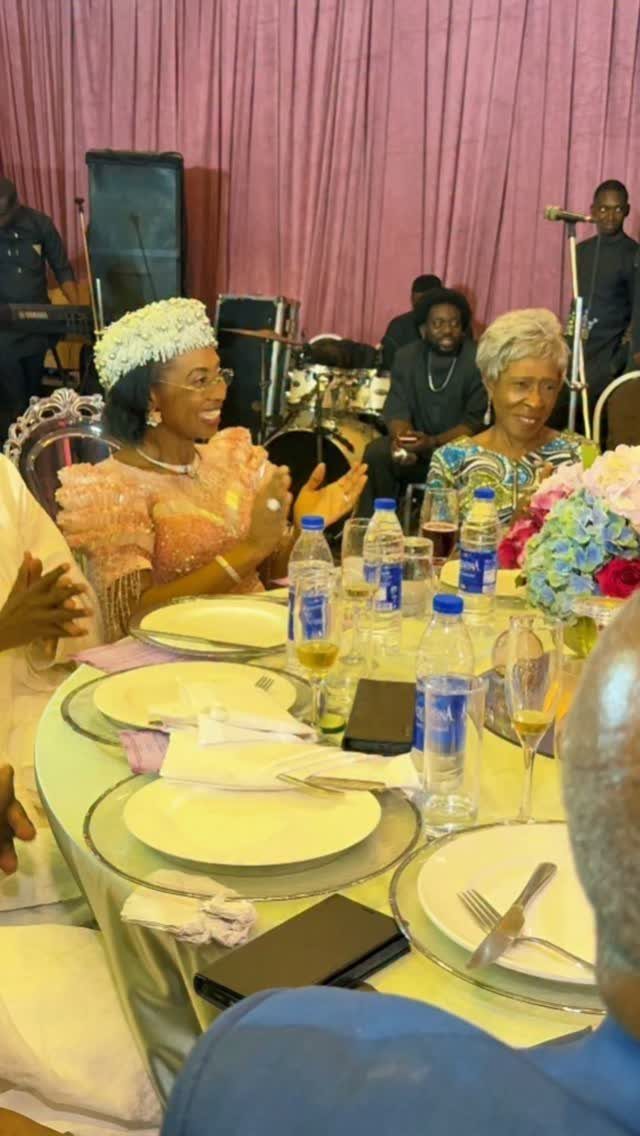 People dining at a celebratory party with musicians performing in the background.