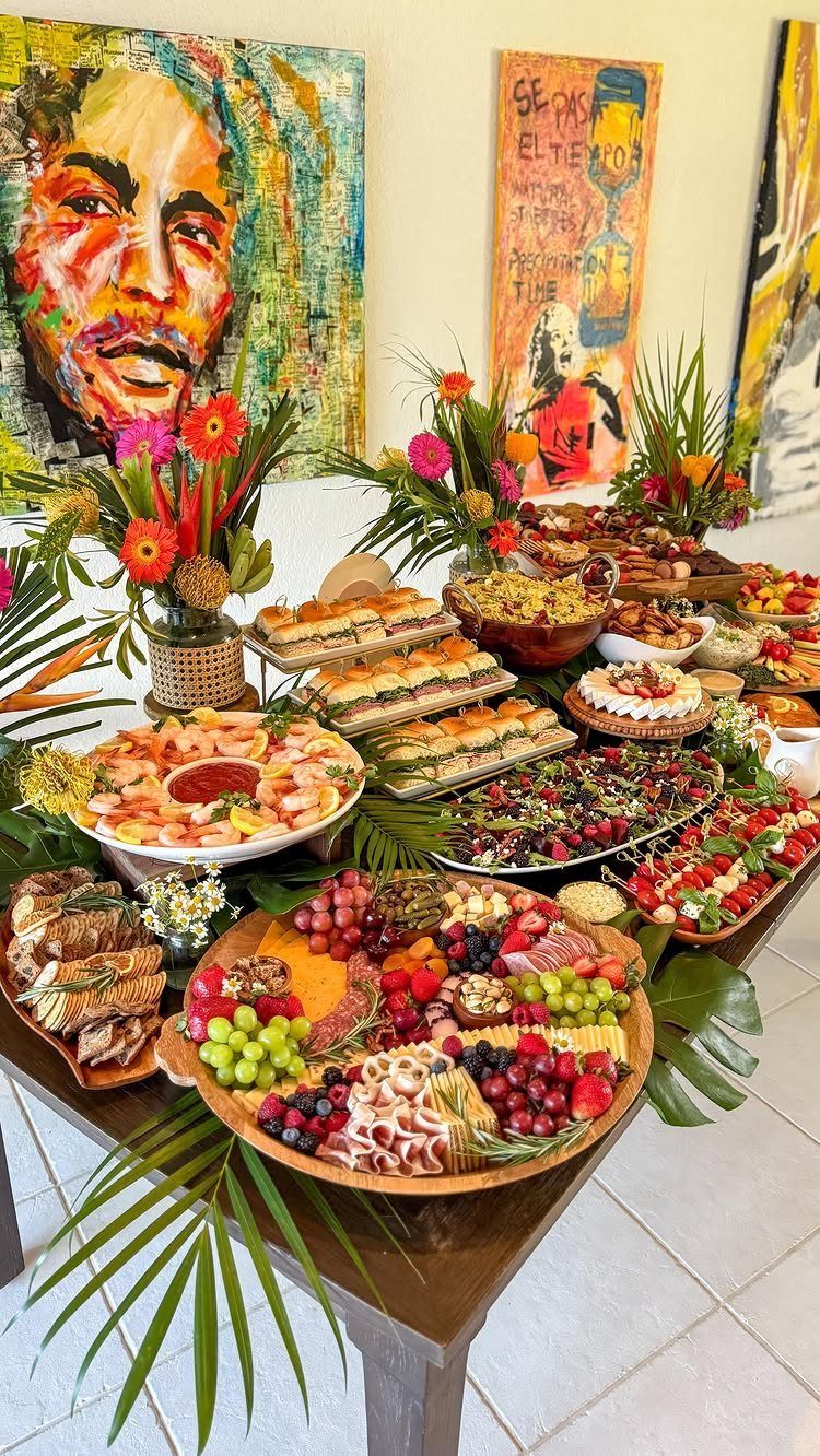 Lavish food spread with charcuterie, shrimp, and fruit on a wooden table.