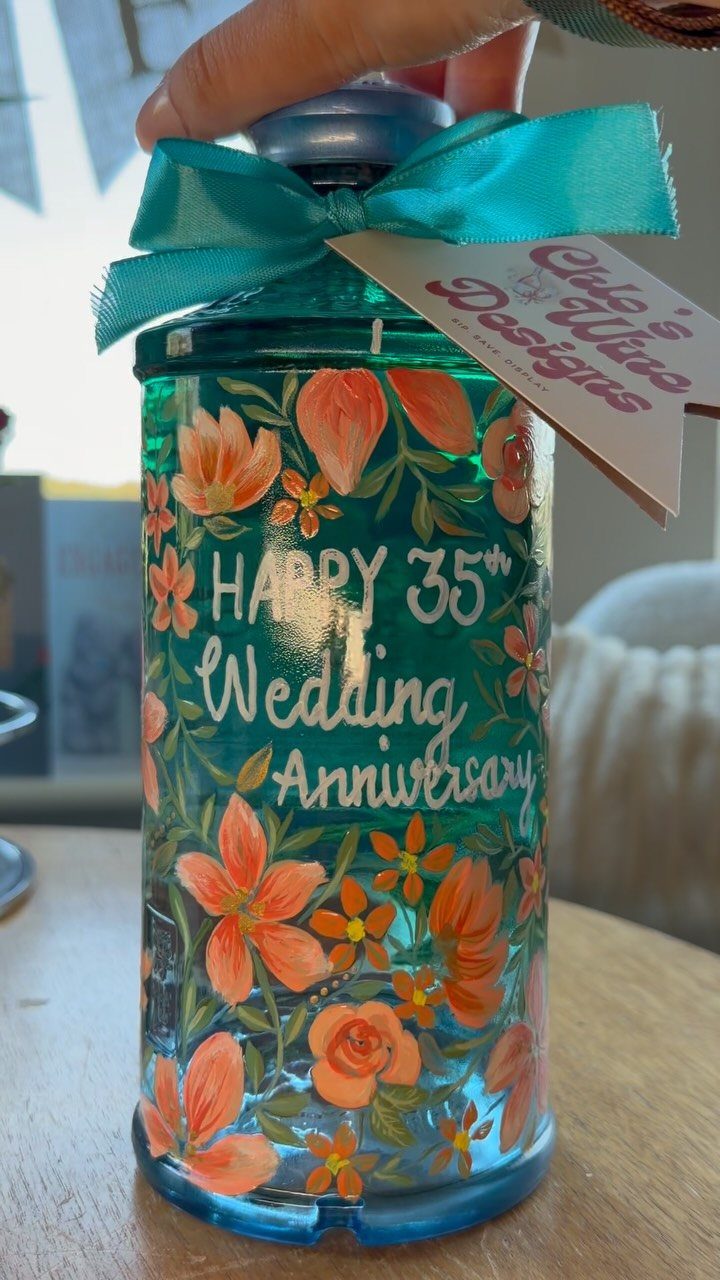 Teal glass bottle painted with orange flowers for a 35th wedding anniversary gift.