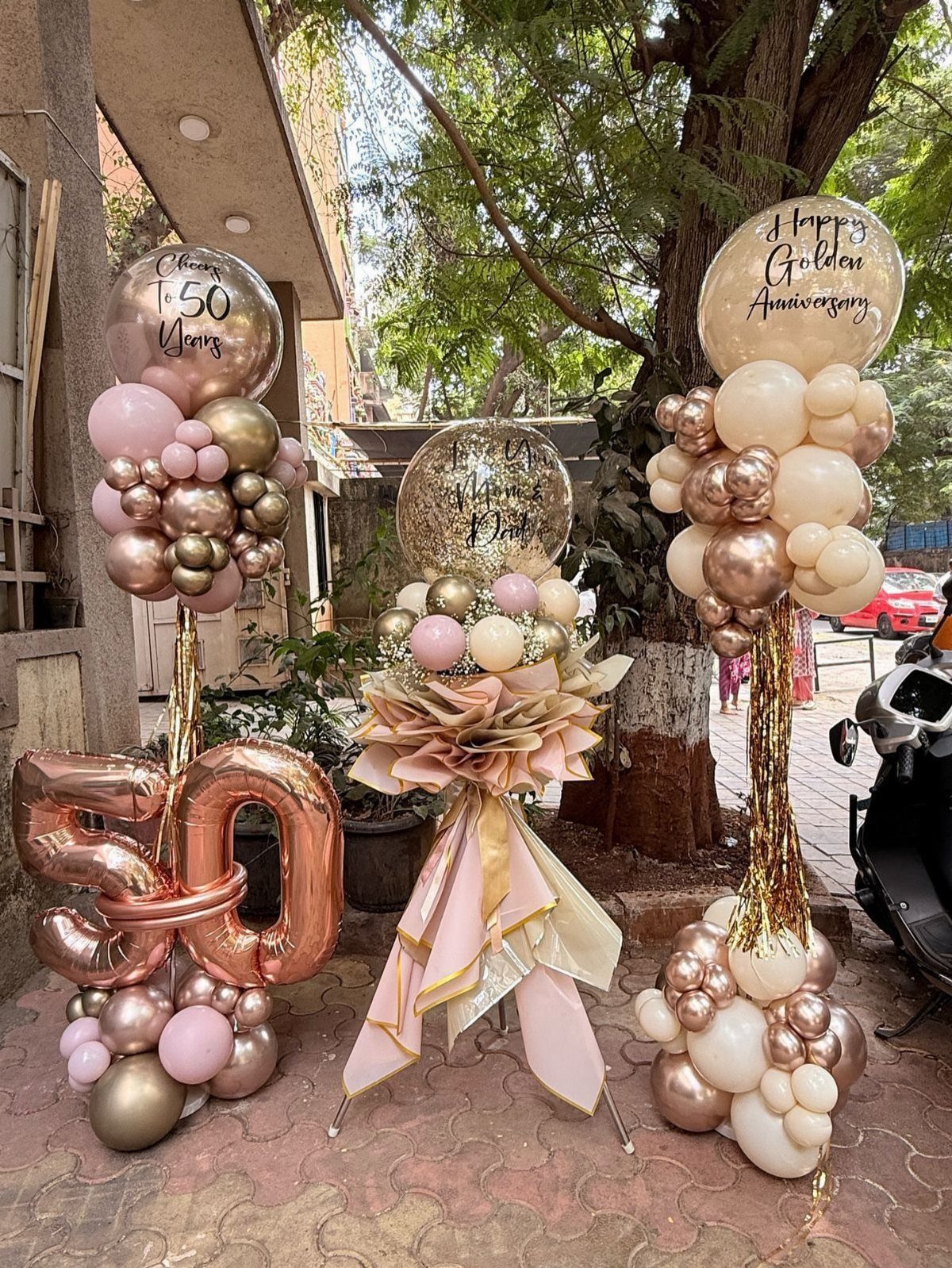 Rose gold and cream balloon decorations with a large number 50 for anniversary.