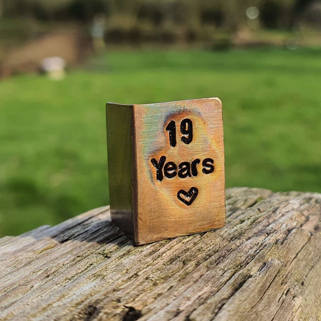 Bronze metallic cube engraved with 19 Years and a heart on weathered wood