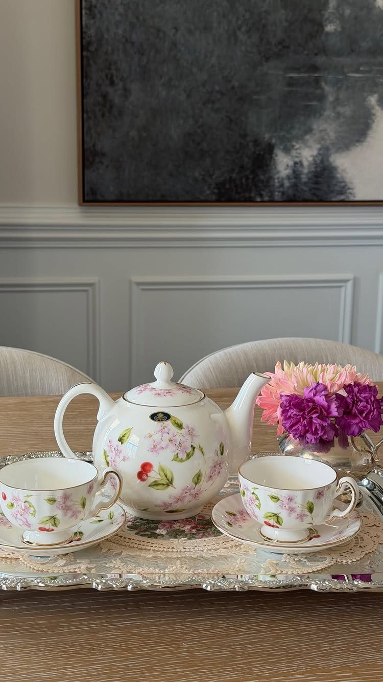 Floral china tea set with teapot and cups on a silver tray.