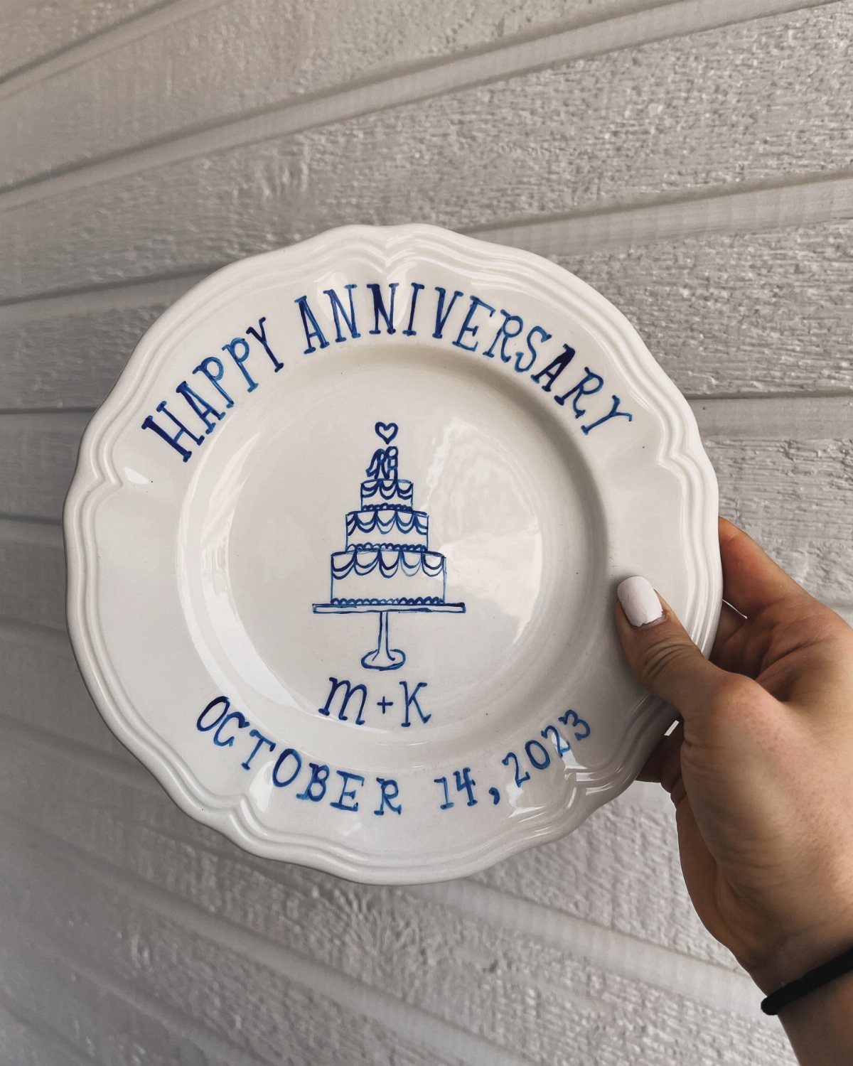 White porcelain anniversary plate with blue cake illustration and personalized date and initials.