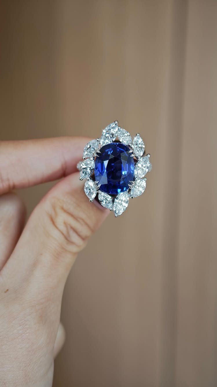 Silver ring with a large oval blue sapphire surrounded by white diamonds.