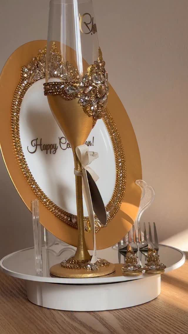 Decorated gold champagne flute and anniversary frame on a white circular tray