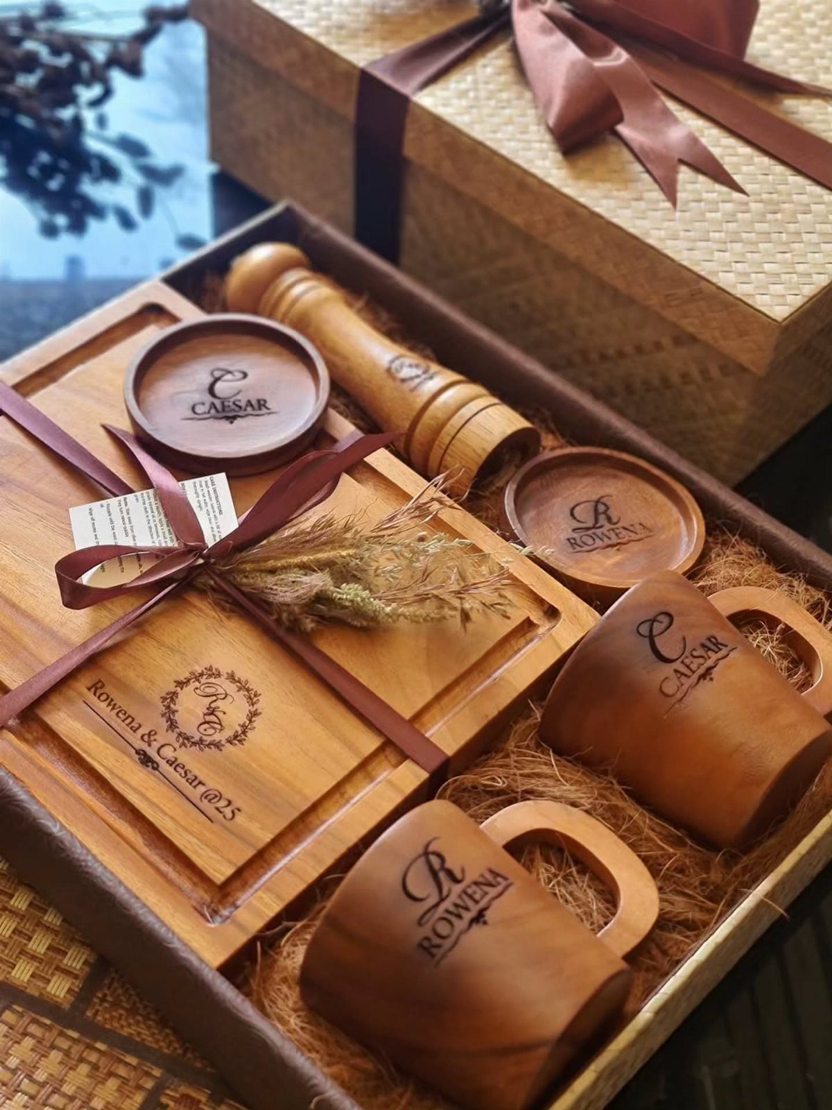 Engraved wooden cutting board and matching mugs in a gift box with ribbon
