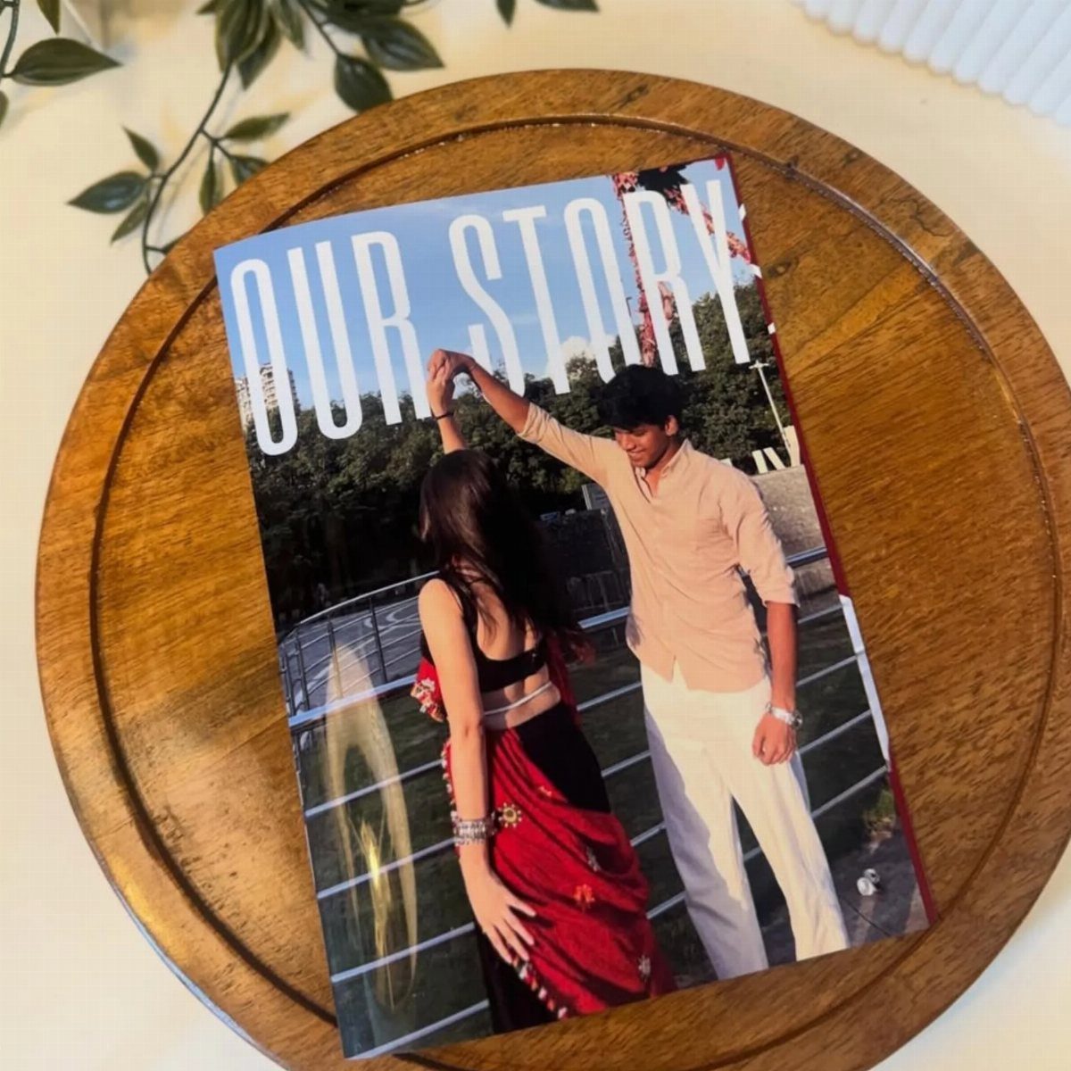 Personalized love story book with a dancing couple on the cover on wooden tray