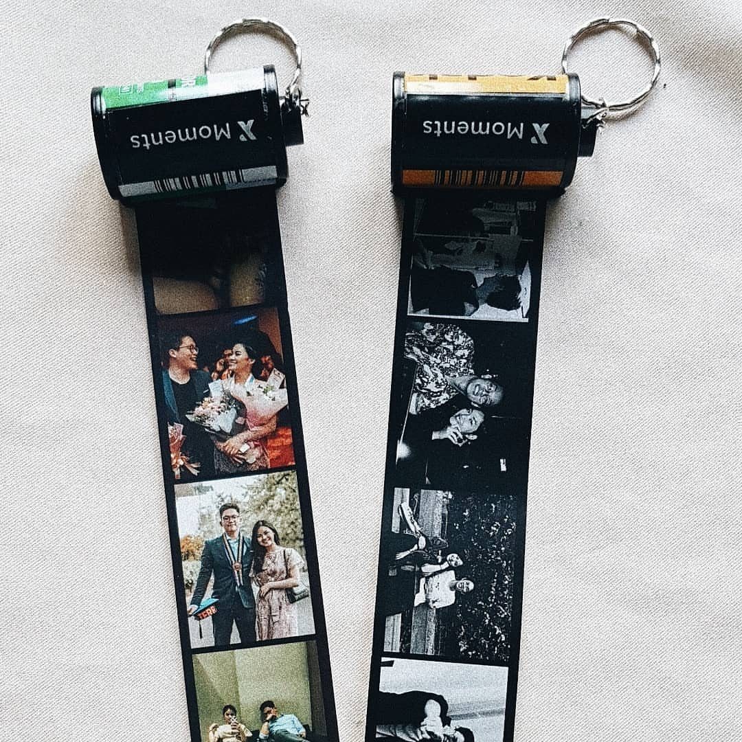 Two custom film roll keychains with pull-out strips of personal couple photographs.
