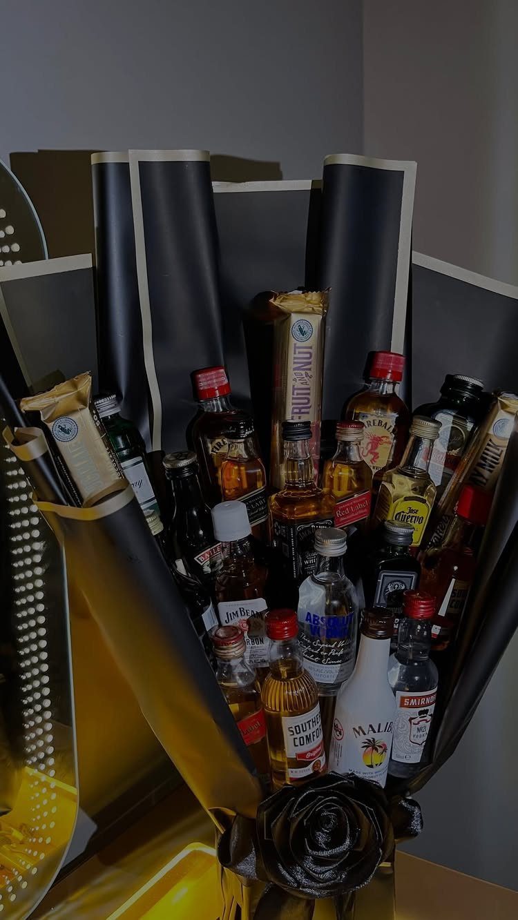 Miniature liquor bottles arranged as a bouquet in black and gold wrapping.