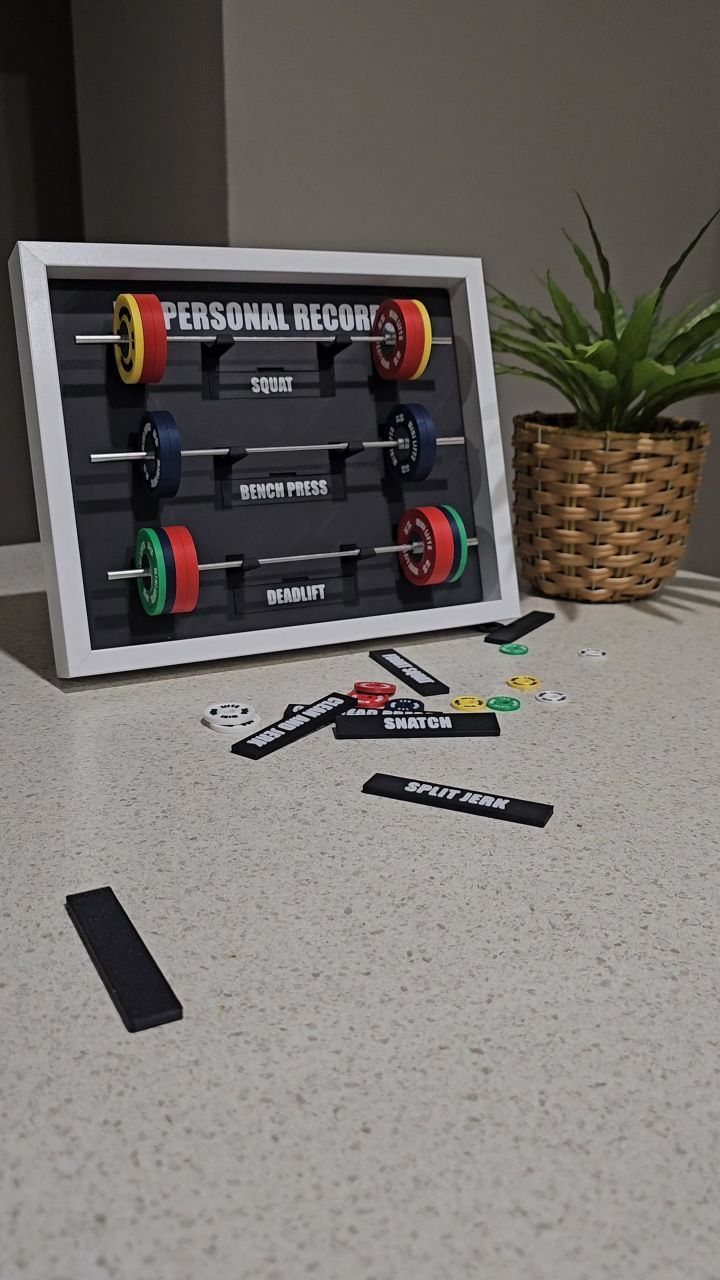 3D wall art displaying miniature barbells for tracking personal gym records on a counter