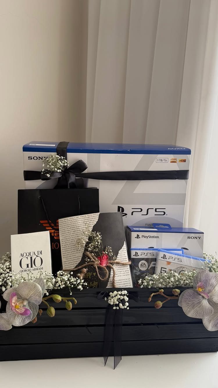 PlayStation 5 console box and accessories arranged in a decorated black gift crate.