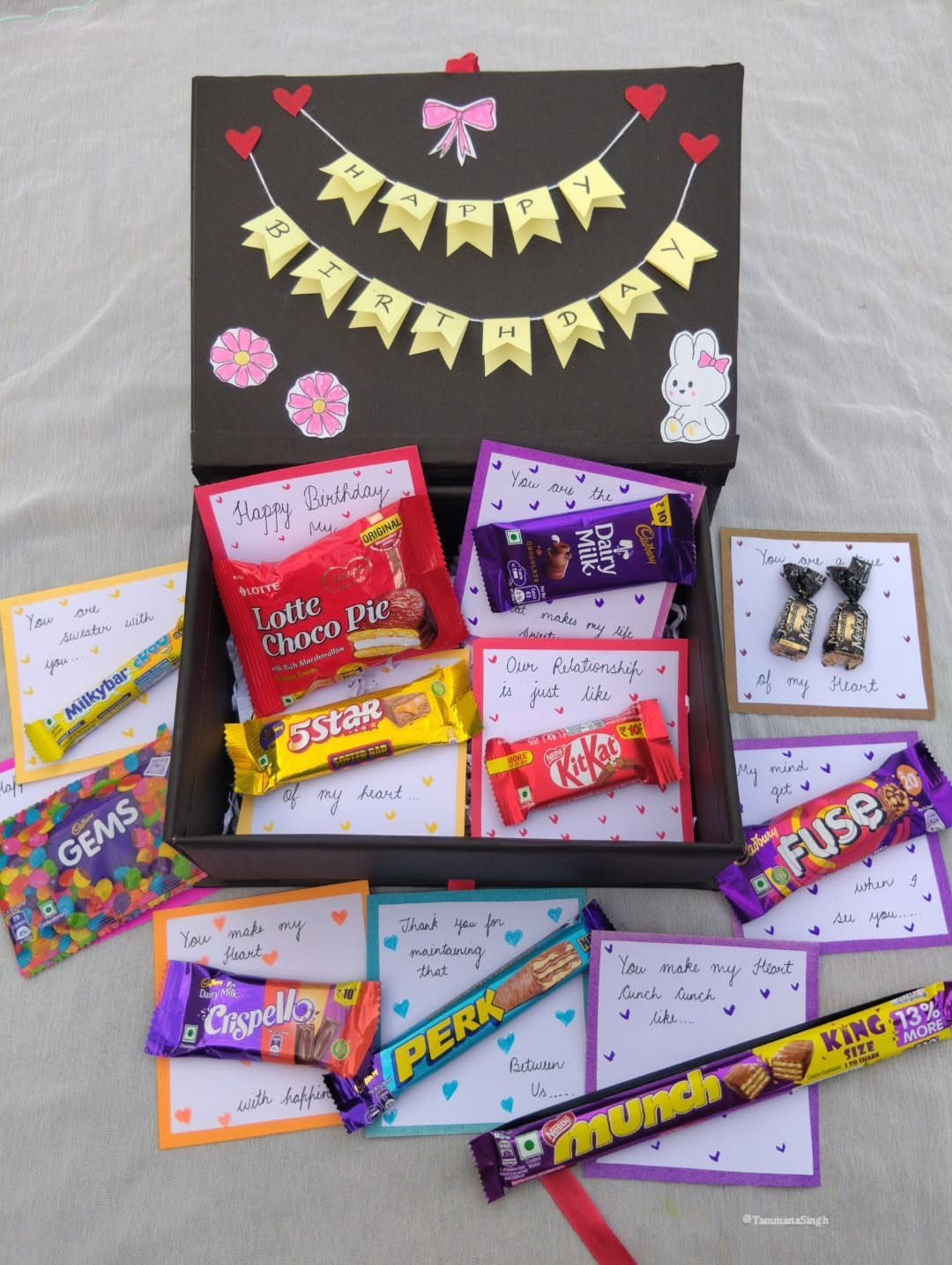 Black birthday gift box filled with assorted chocolates and handwritten heartfelt notes.
