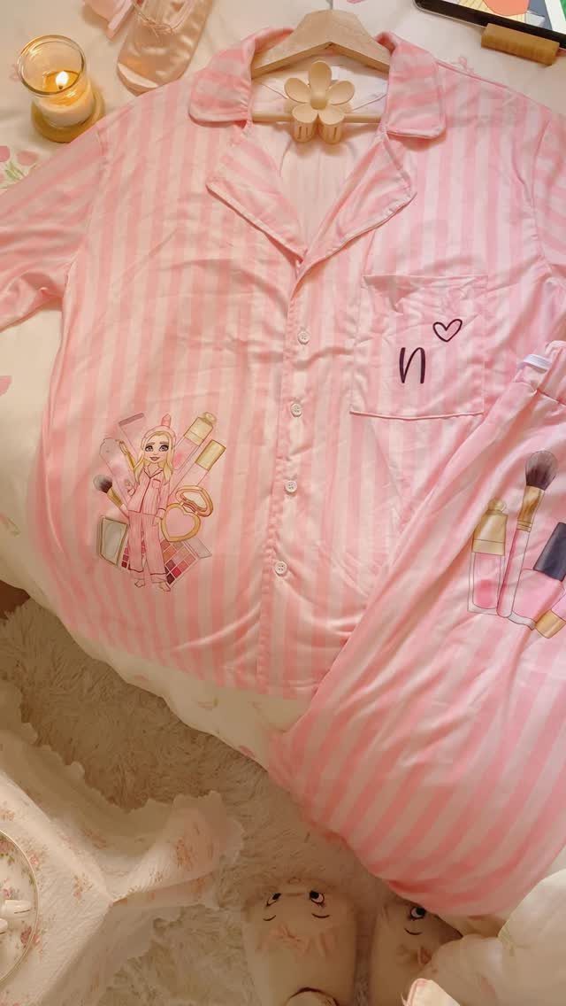 Pink and white striped satin pajamas with a cartoon character on a fluffy rug