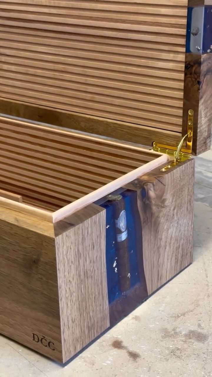 Wooden cigar humidor with blue resin inlay and gold hinges, open to show interior.