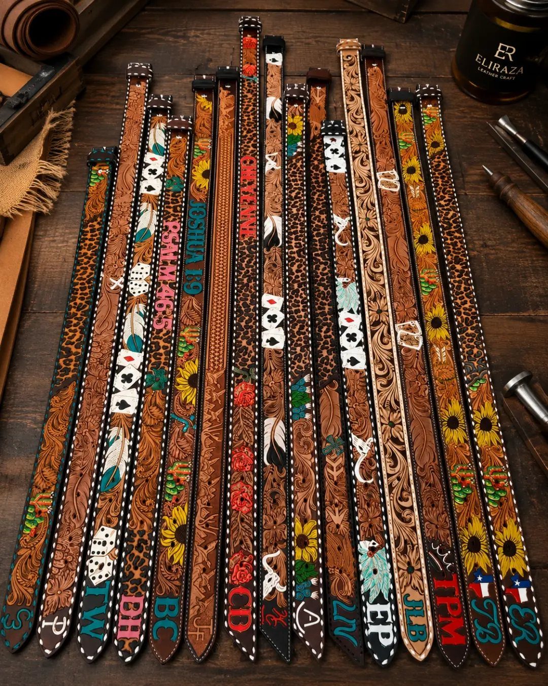 Assorted decorative leather belts with intricate carvings and embroidery on a wooden table