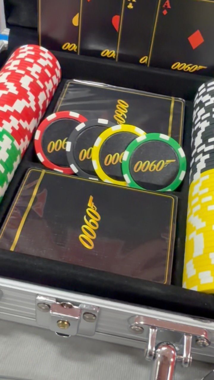 Poker set in a silver case with colorful chips and black playing cards.