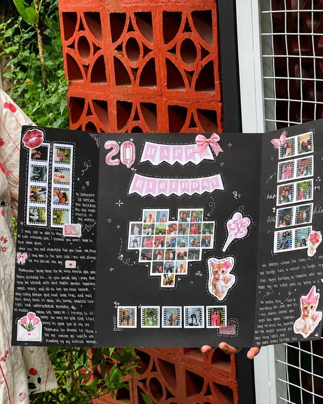 Handmade black scrapbook with photo collages, handwritten messages, and decorative stickers.