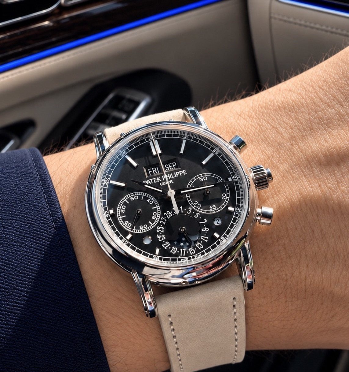Luxury Patek Philippe watch with black face and leather strap on a wrist