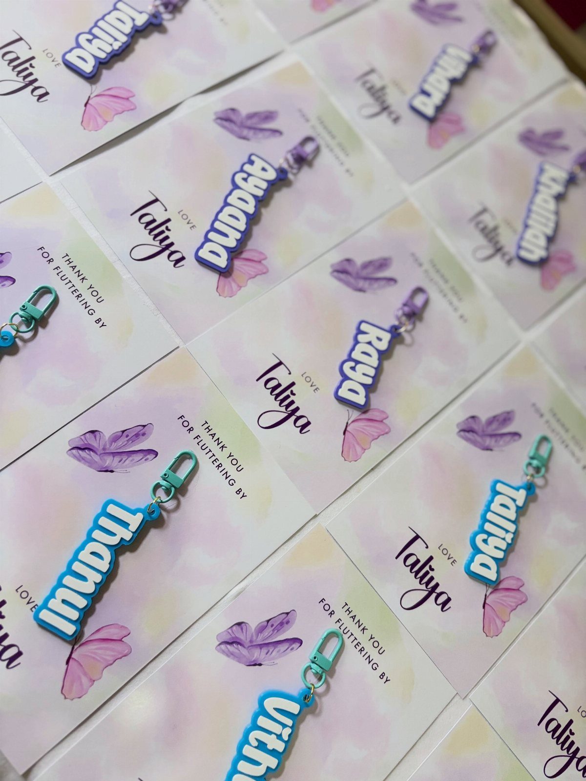 Custom acrylic name keychains attached to floral thank you cards for party guests.