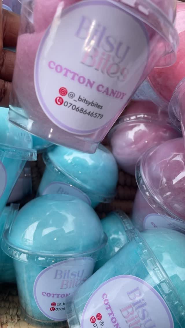 Pink and blue cotton candy in small clear plastic containers with custom labels.