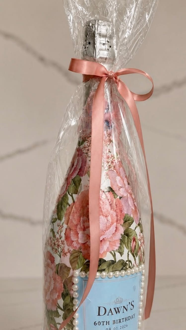 Mini champagne bottle with floral wrap and custom 60th birthday label in cellophane