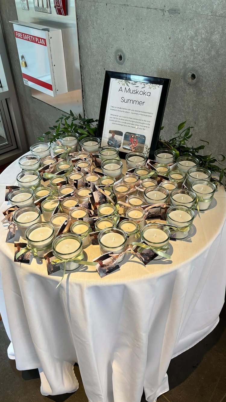 Small glass votive candles with attached photos on a white draped table.