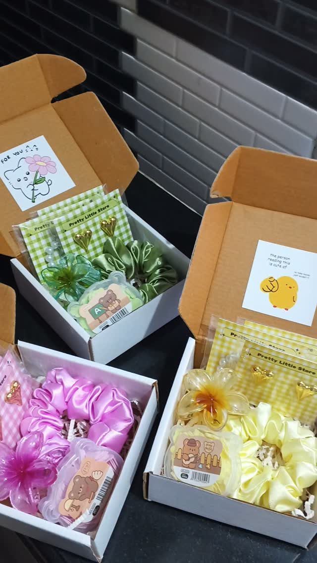 Colorful hair scrunchies and clips in open gift boxes with cute cards.