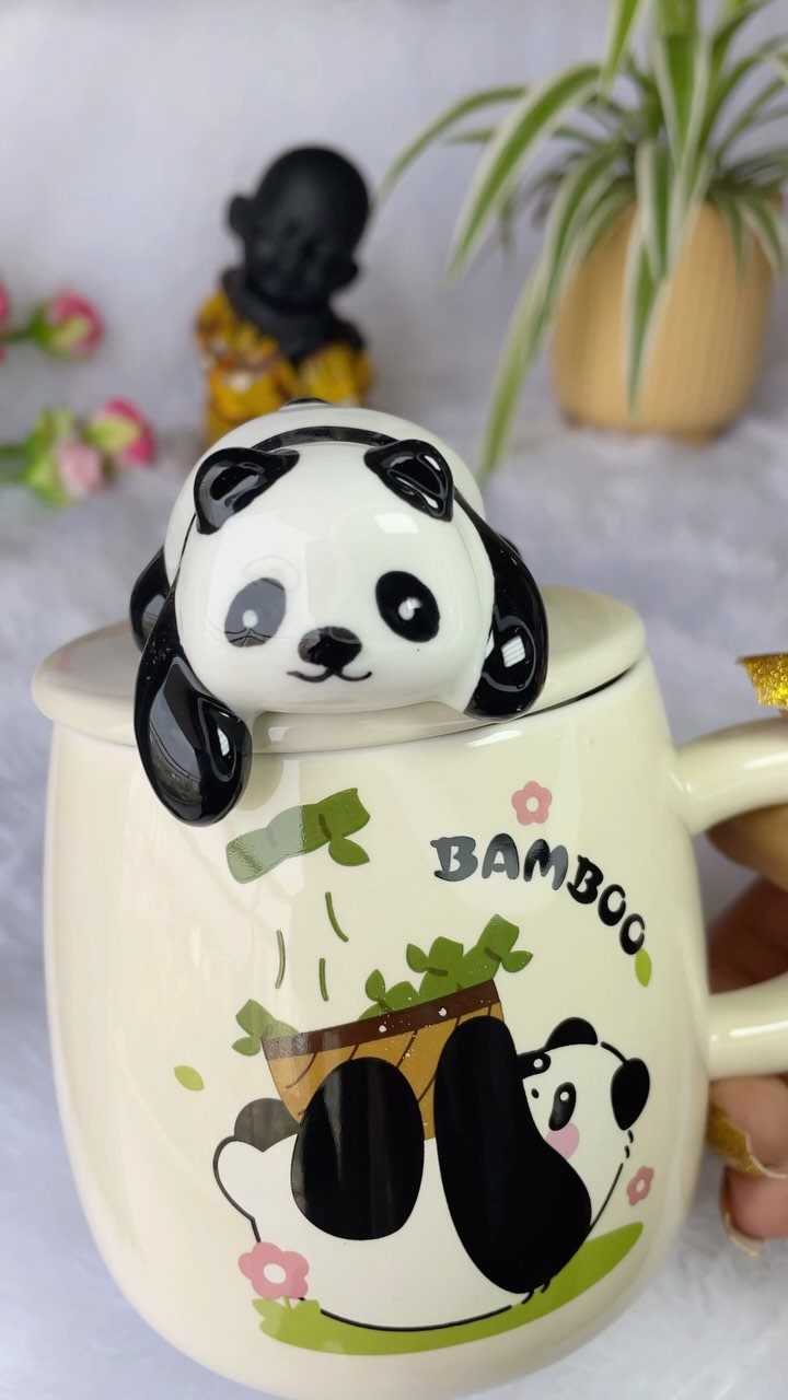 Cream ceramic panda mug with a small panda figure on the lid.