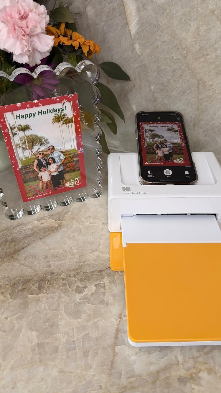 Kodak instant photo printer with a smartphone and a printed family holiday card.