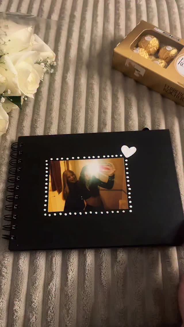 Black spiral notebook with a photo of two friends and a white heart.
