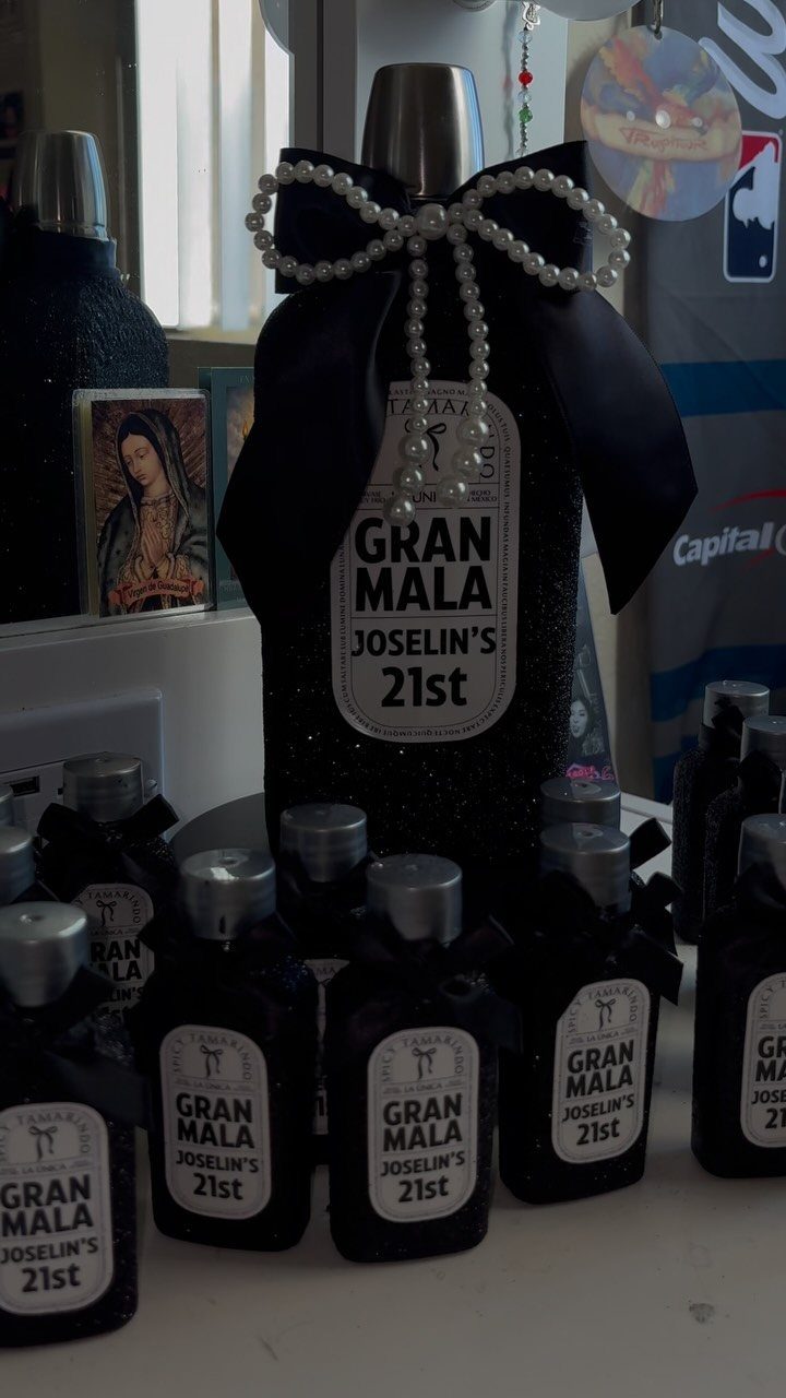 Black glittery bottles with custom 21st birthday labels and pearl bow decoration