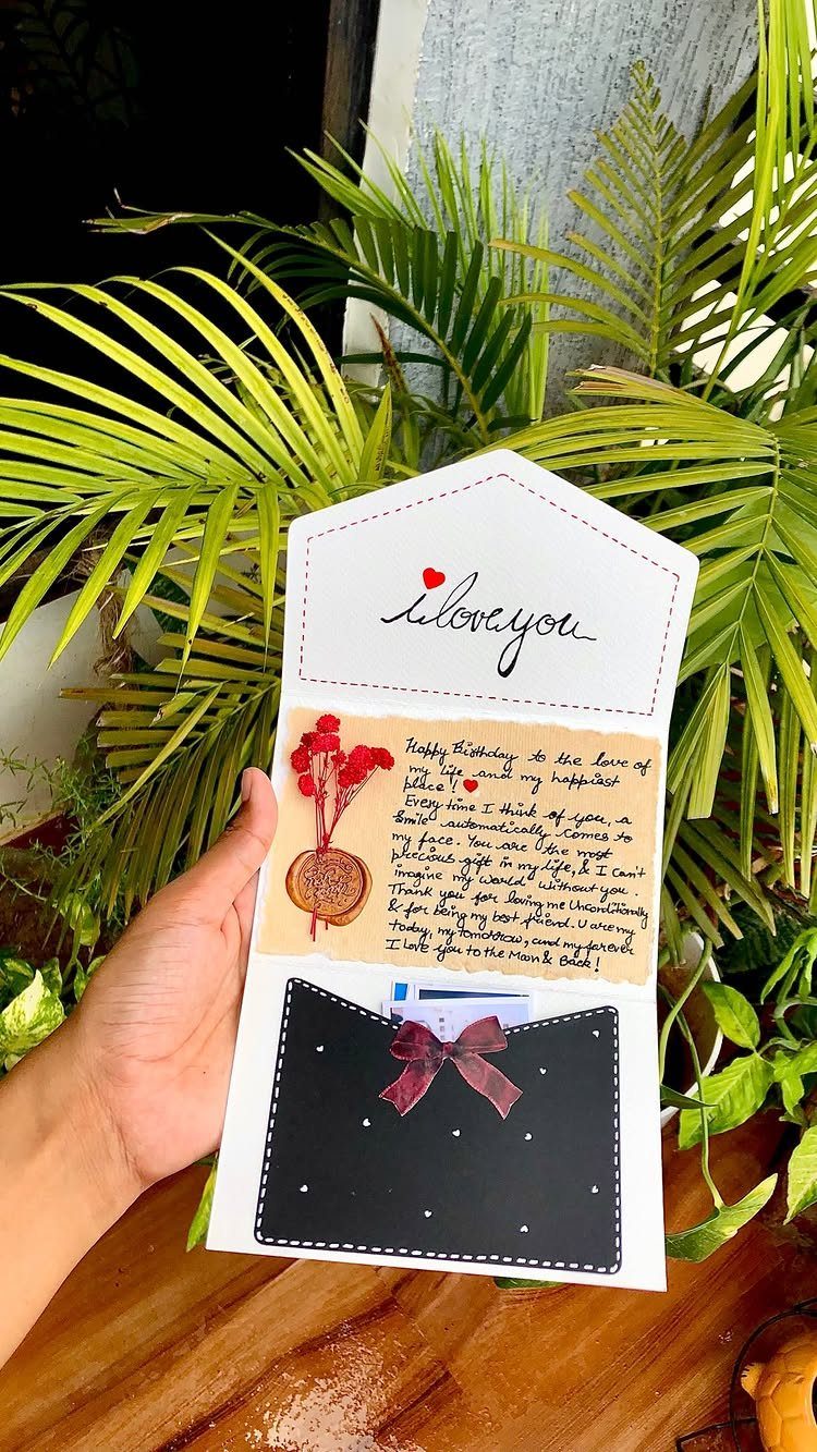 Handmade envelope card with a love letter, dried flowers, and a small photo.