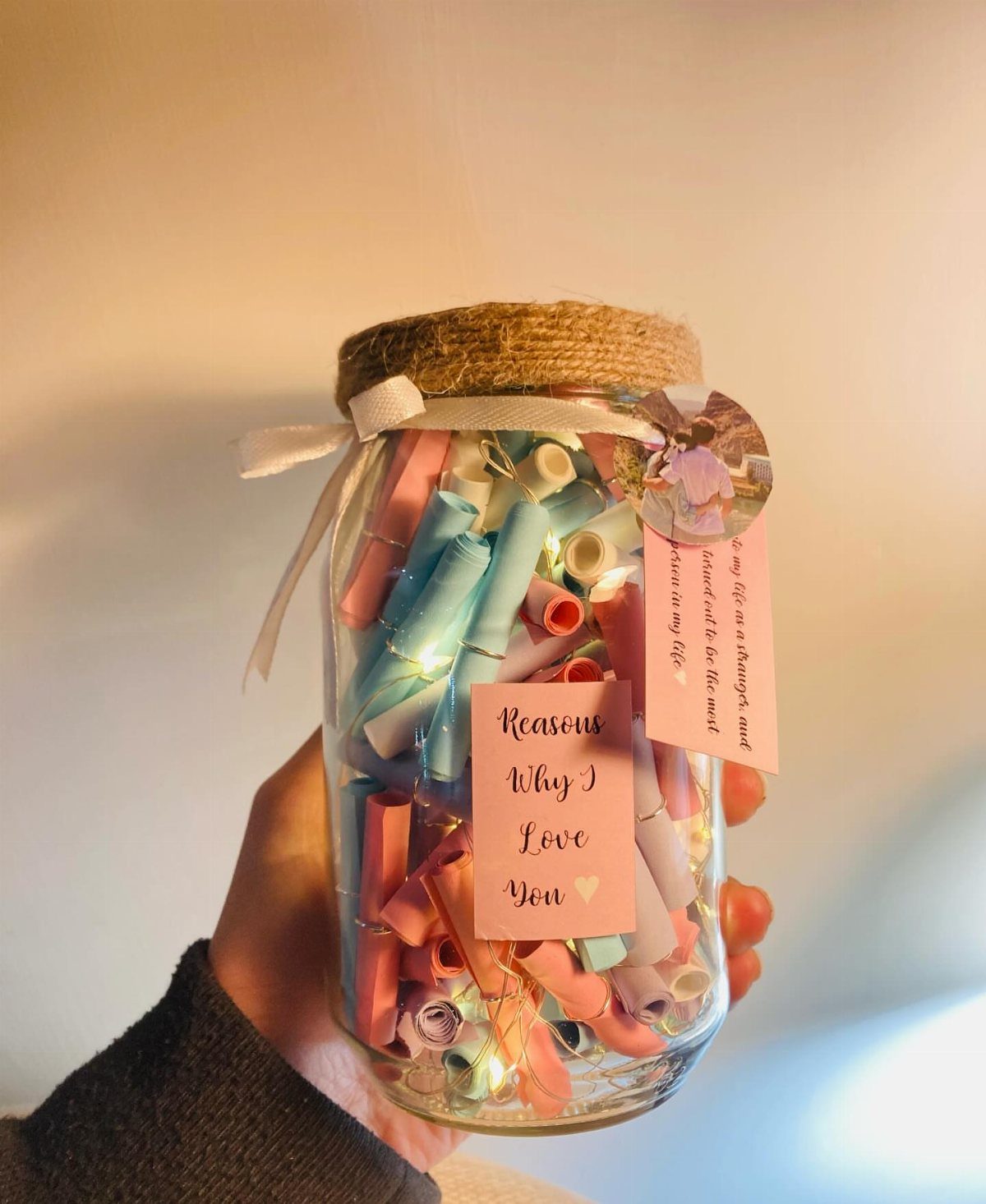 Glass jar filled with rolled pink and blue notes and a love label.