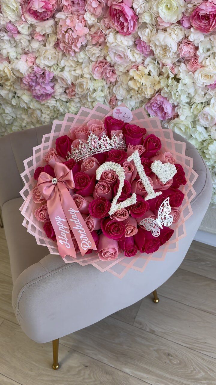 Bouquet of pink and red roses with a tiara and number 21 decoration.