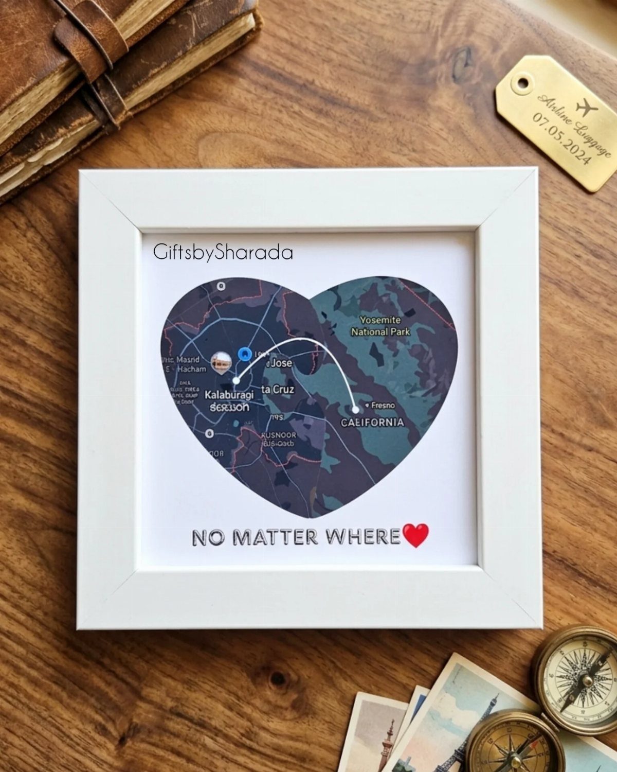 Heart-shaped map in a white frame connecting two distant locations on wood.