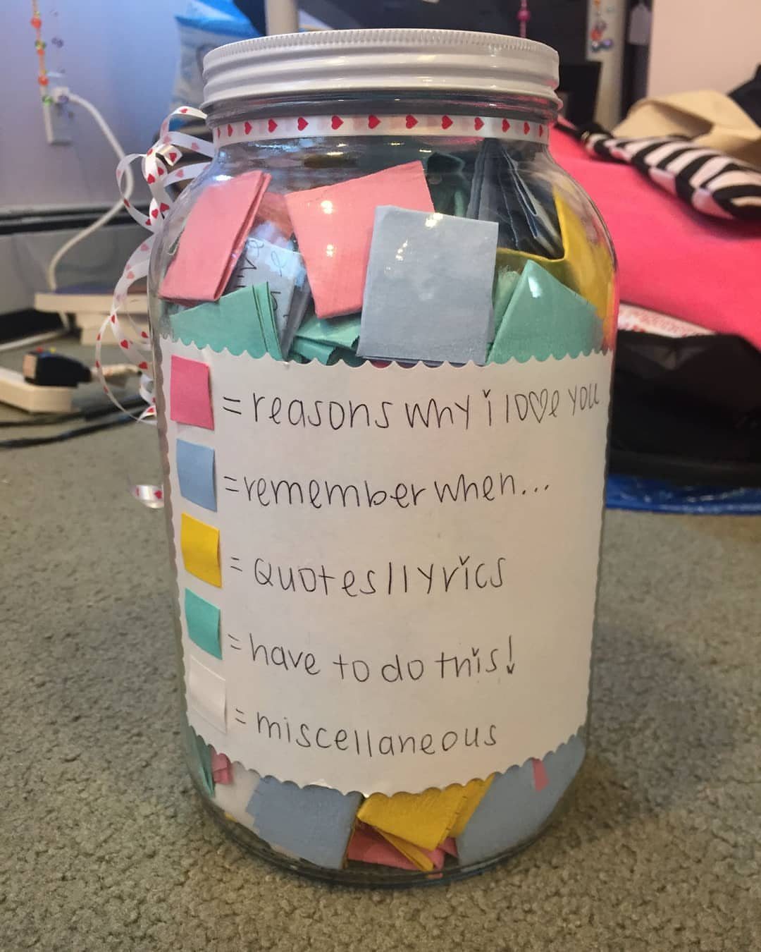 Glass jar filled with colorful paper notes and a handwritten category label.