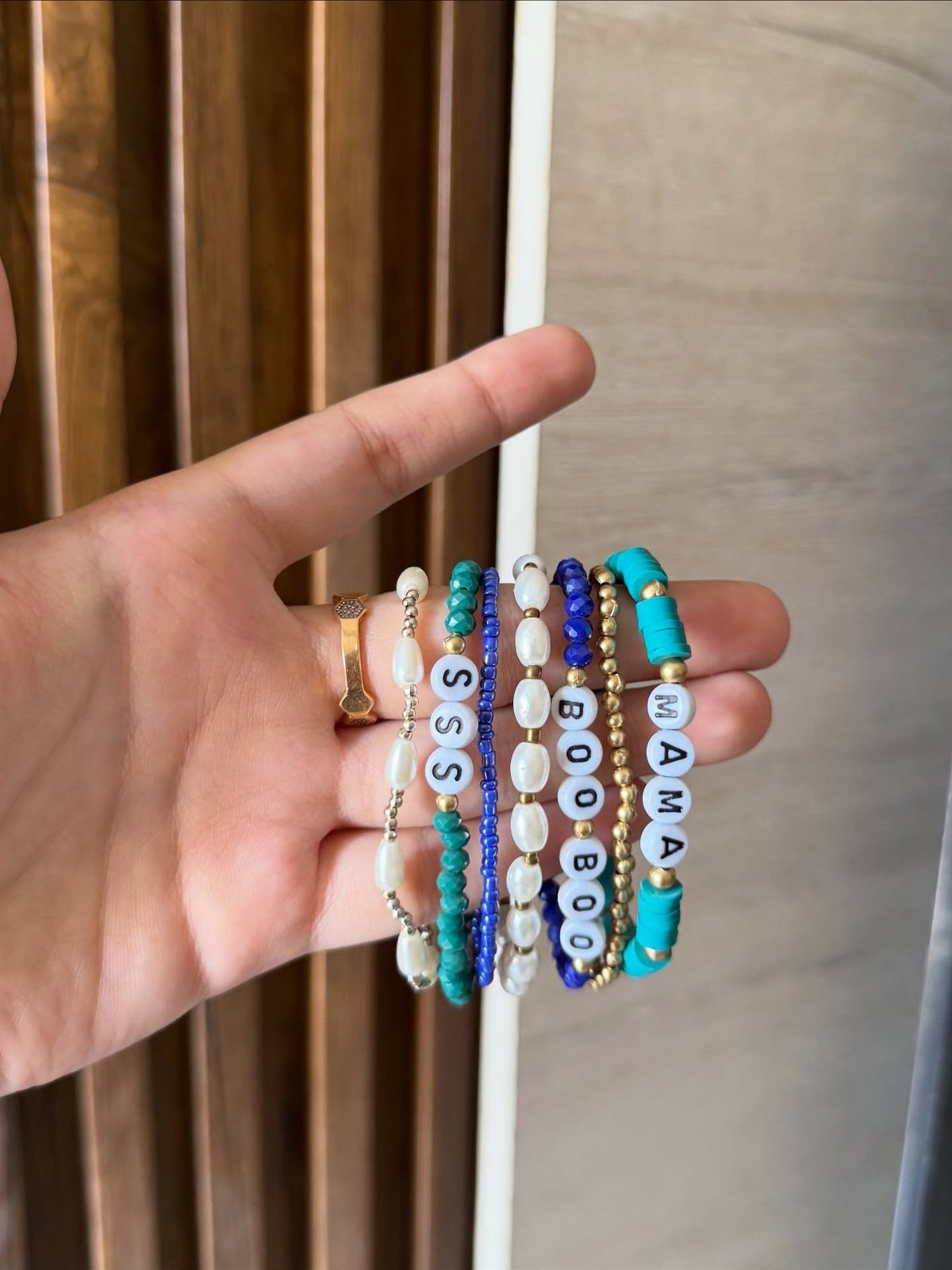 Beaded bracelets with letter beads spelling MAMA and BOOBOO held in a hand.