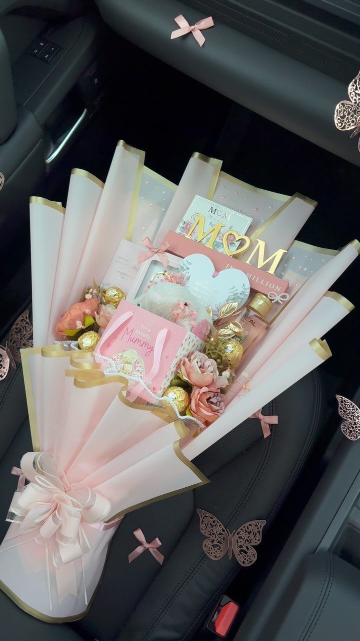 Chocolate and rose bouquet wrapped in pink paper with a gold MOM sign.