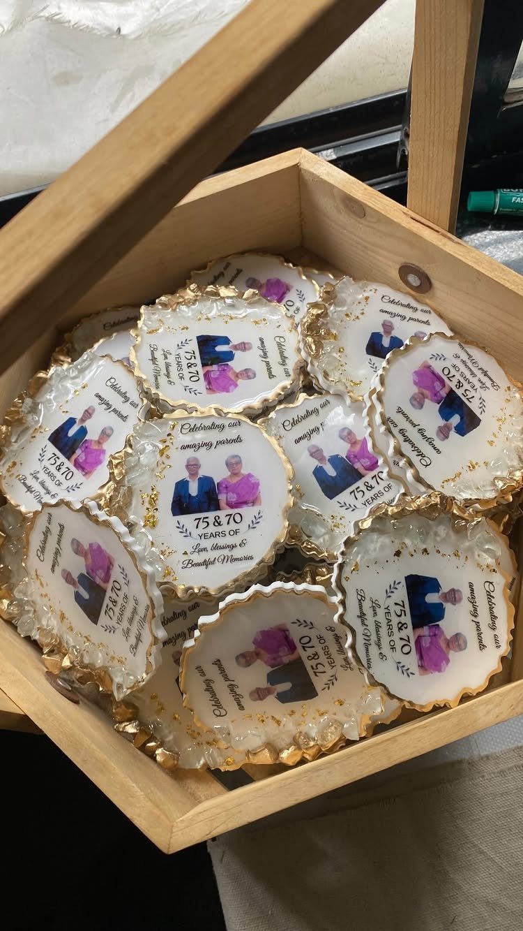 Resin coasters with photos of a couple and gold glitter edges in a box