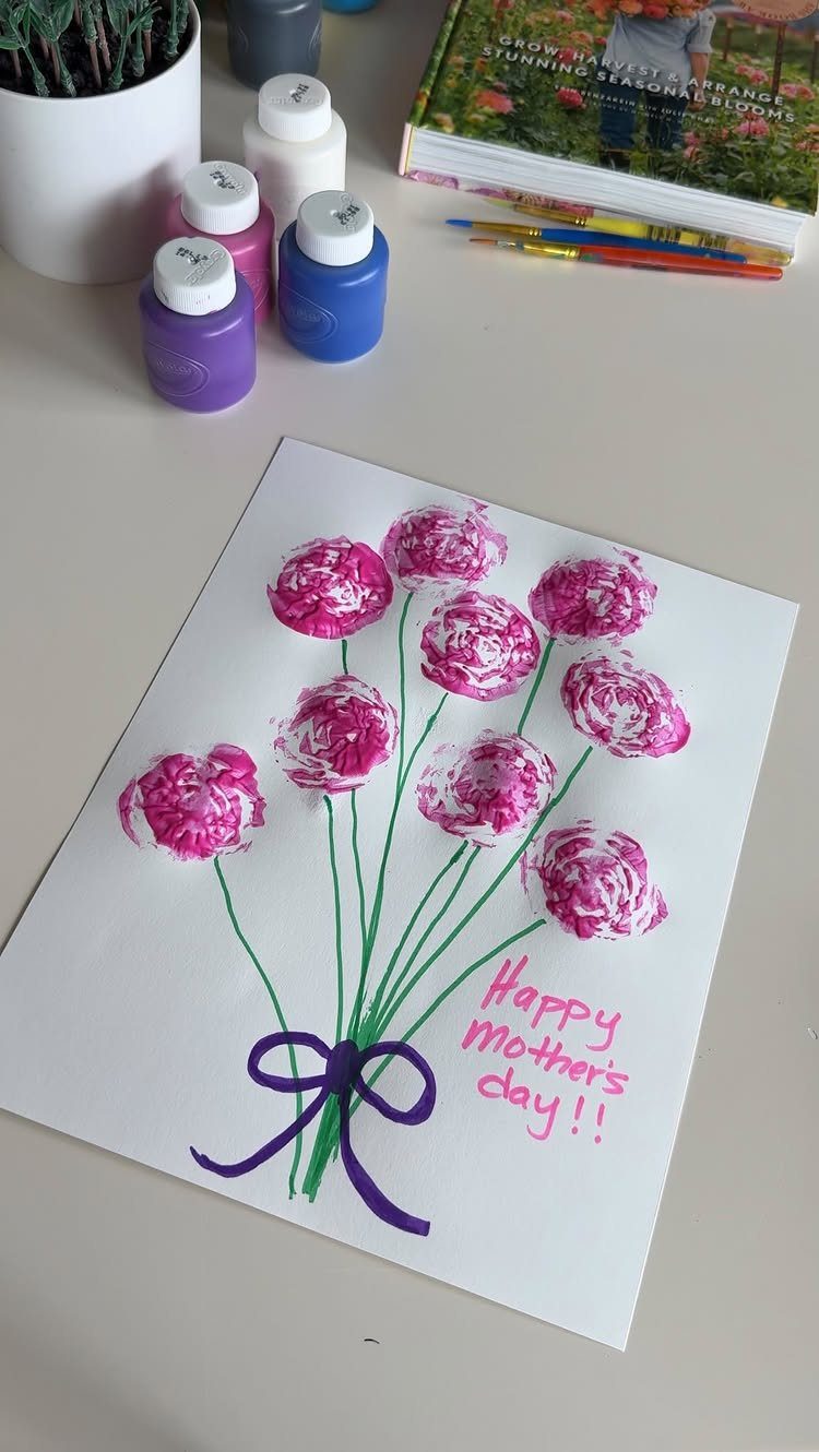 Handmade Mother's Day card with pink painted flowers and a purple bow.