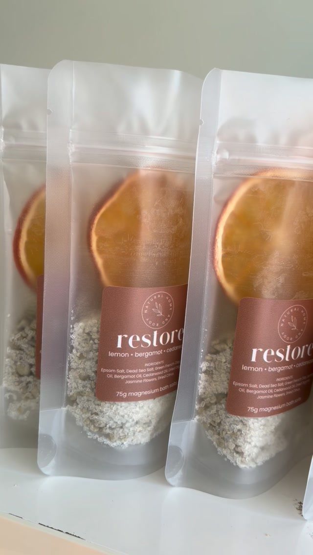 White pouches of bath salts with dried citrus slices and brown labels.
