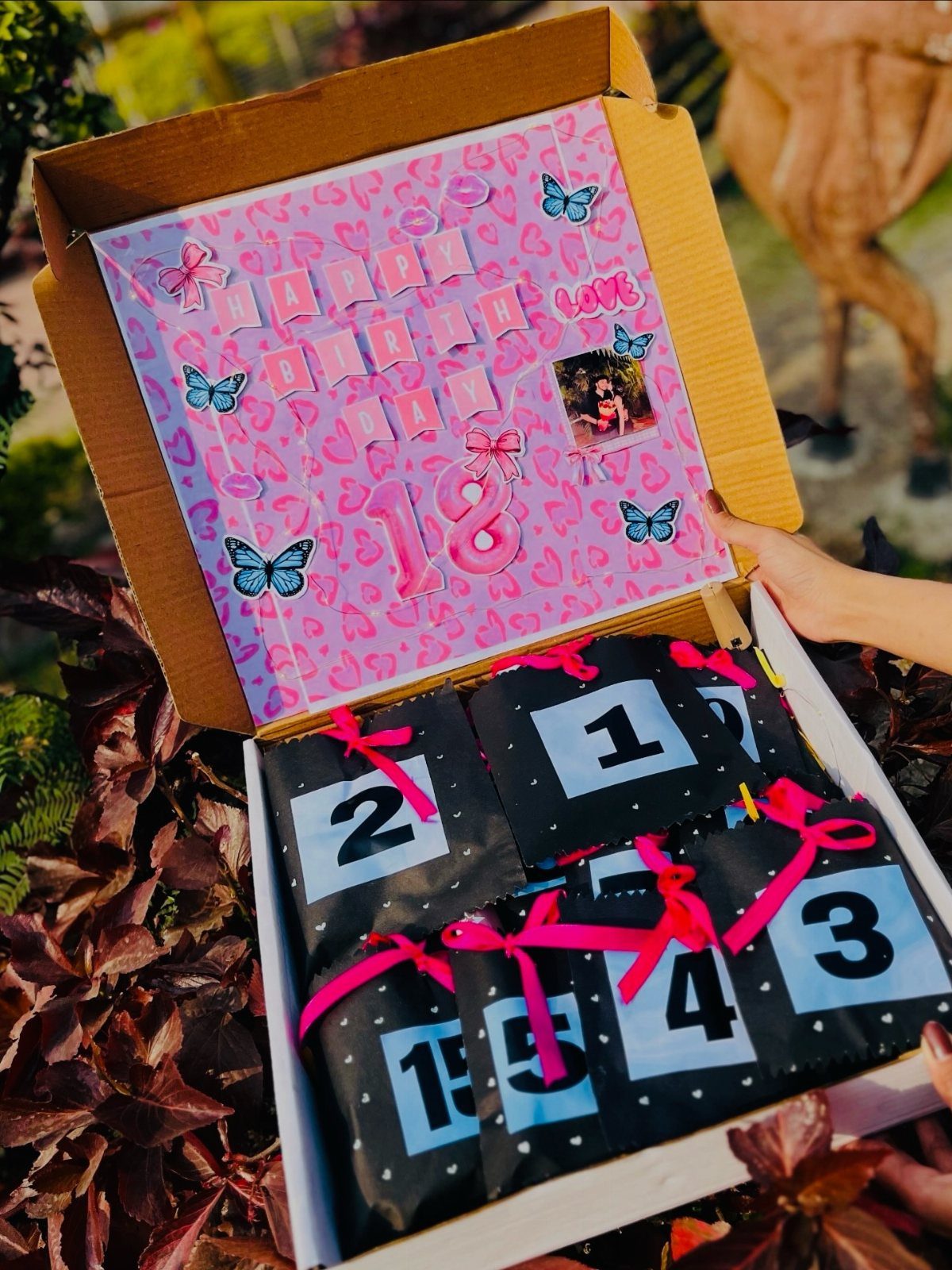 Numbered gift packages in a decorated box with a pink number 18 lid.