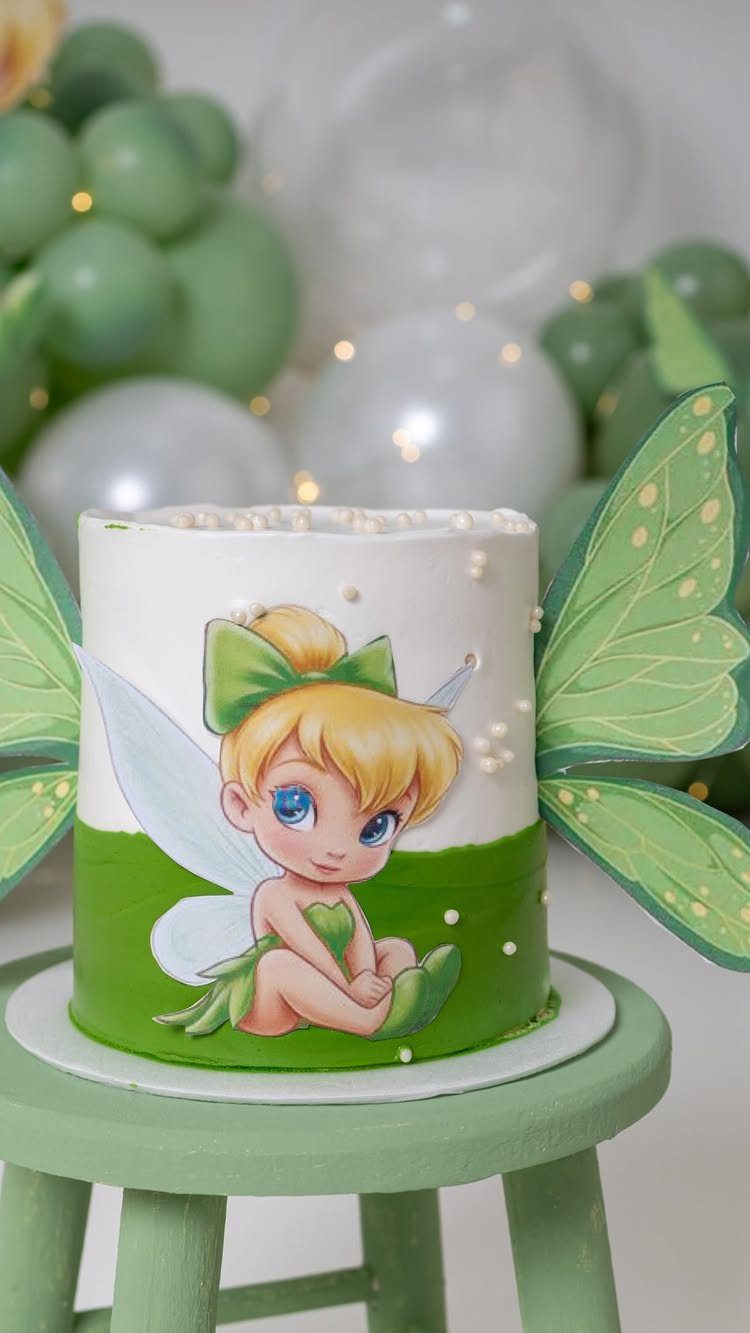 Tinker Bell themed cake with green wings on a light green stool