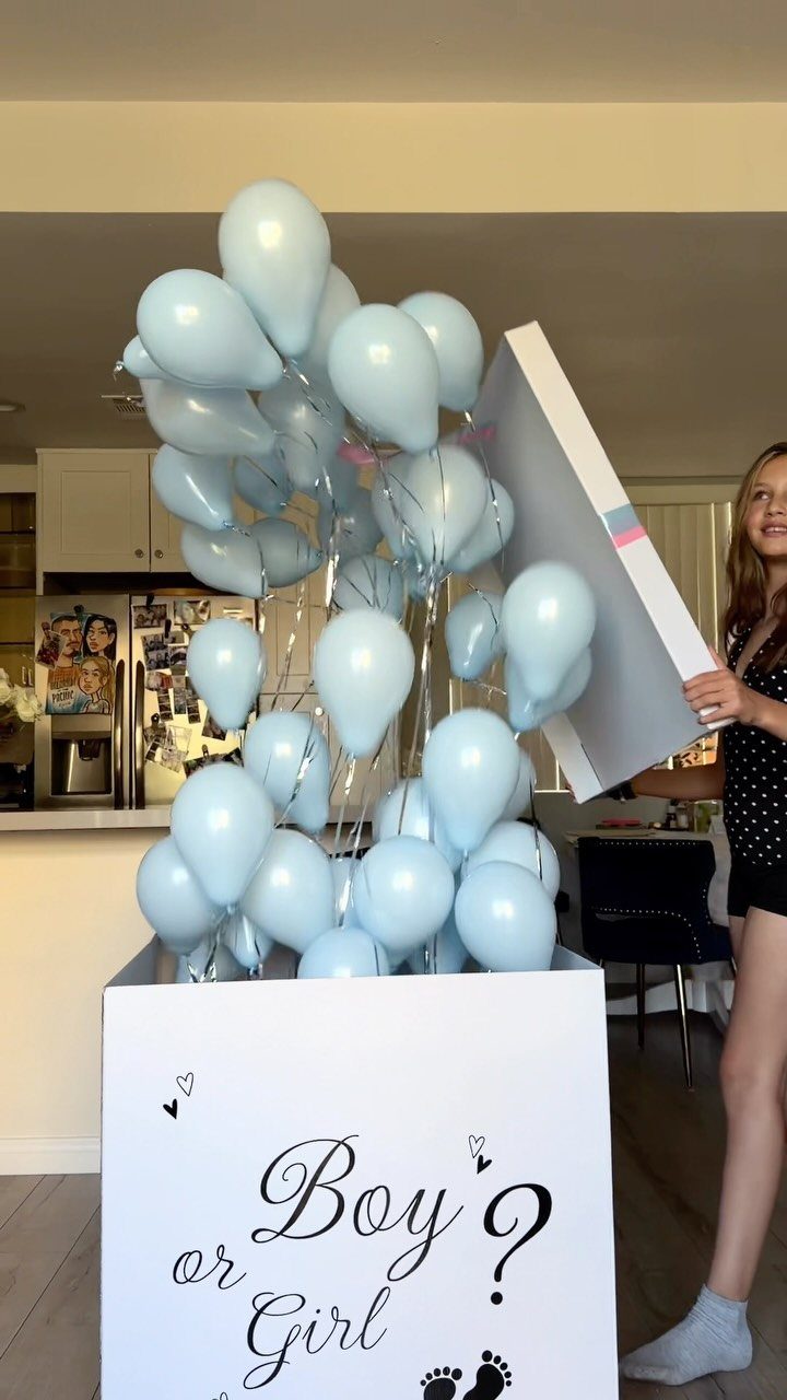 Light blue balloons floating out of a white Boy or Girl reveal box.