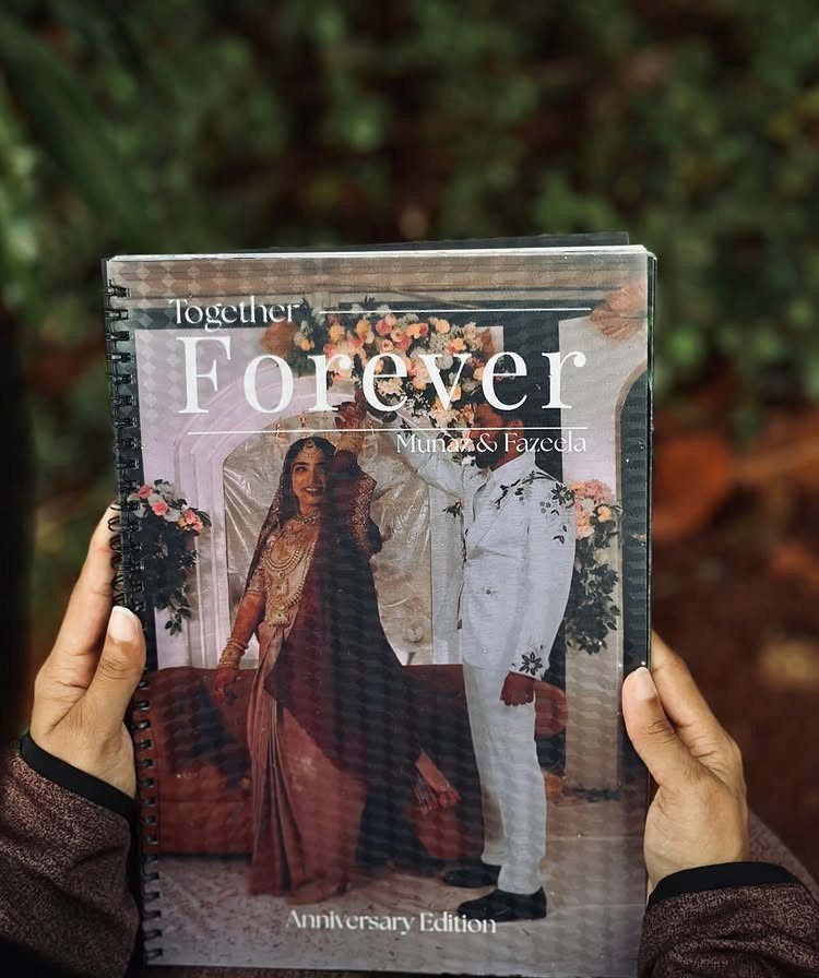 Spiral-bound anniversary photo book featuring a couple in traditional Indian wedding clothing.